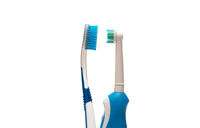 Normal and electric toothbrush facing each other